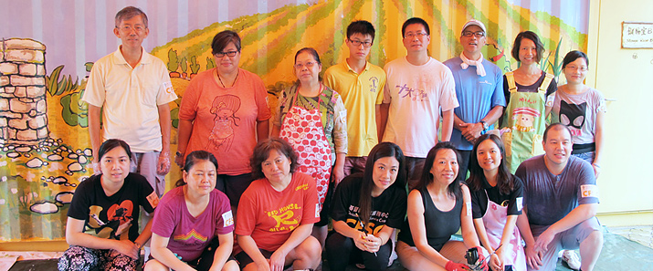 相片1:迪士尼動畫大師Elaine Koo(前排右3)與由社區人士組成的義工合作，為「都市綠洲」內的貨櫃建築物設計壁畫